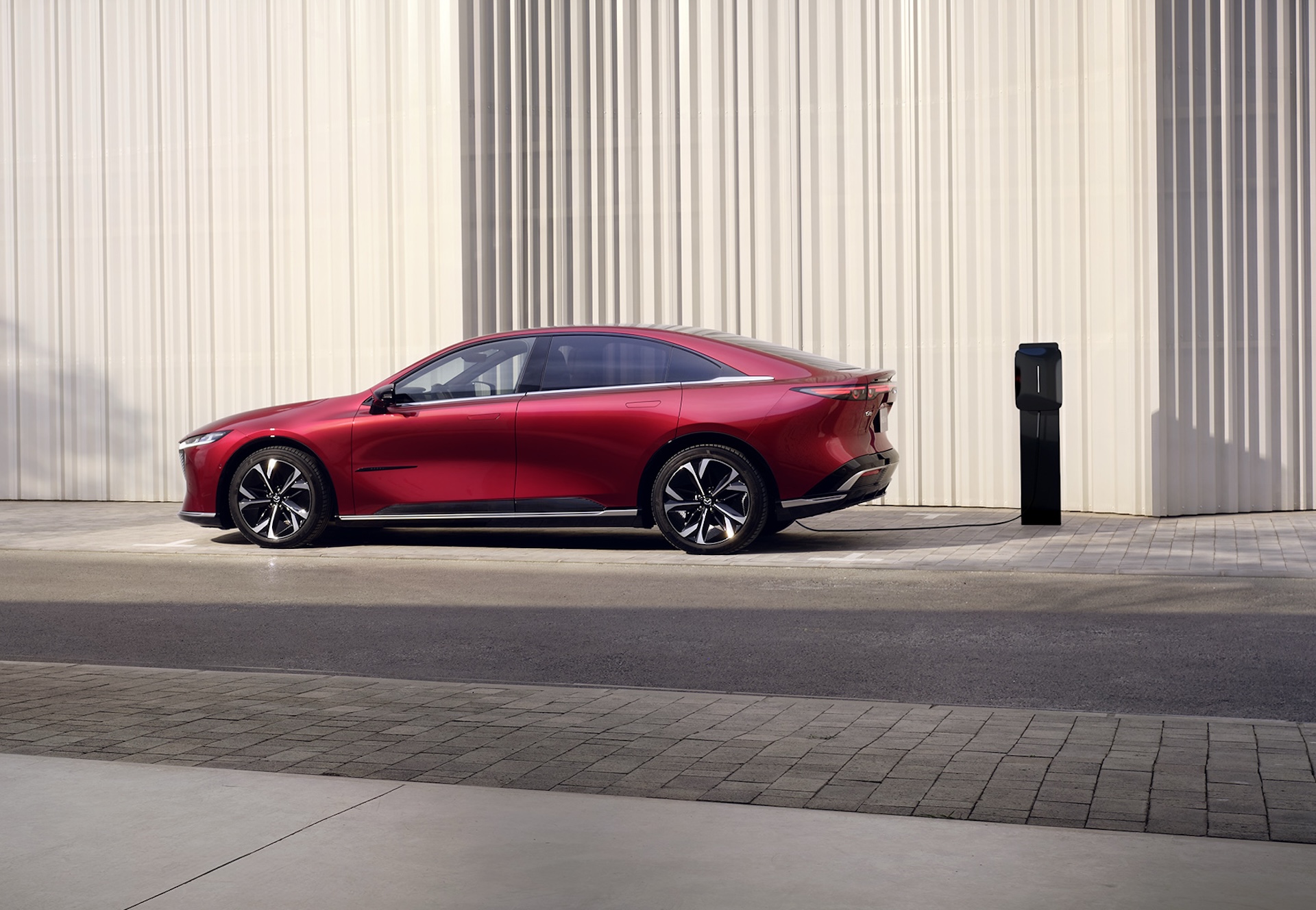 Mazda6e in rood, zijaanzicht bij oplaadpaal
