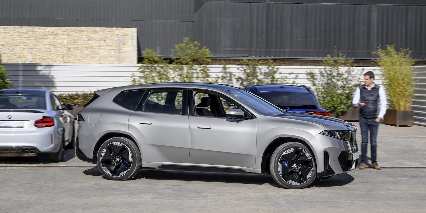 Grijze BMW iX3 in zijaanzicht buiten geparkeerd